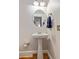 Elegant powder room with pedestal sink, oval mirror, and classic fixtures at 891 Paoli Se Ave, Atlanta, GA 30316