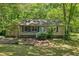 Charming single-story home with lush landscaping, and a covered parking area, nestled amongst mature trees at 1410 Cobb Branch Dr, Decatur, GA 30032
