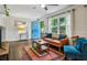 Cozy living room featuring stylish decor, hardwood floors, wainscoting detail, and natural light from the windows at 1410 Cobb Branch Dr, Decatur, GA 30032