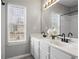 Bright bathroom featuring double sink vanity, large mirror, and tub with shower at 4044 Spring Cove Dr, Duluth, GA 30097