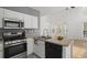 Bright kitchen features stainless steel appliances, white cabinetry, and a cozy breakfast nook with large windows at 4044 Spring Cove Dr, Duluth, GA 30097