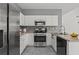 Galley kitchen features stainless steel appliances and white cabinets with gray walls at 4044 Spring Cove Dr, Duluth, GA 30097