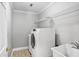 Bright laundry room featuring a modern washer/dryer, utility sink, and overhead wire shelving at 740 Creek Wind Ct, Duluth, GA 30097