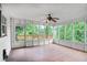 Enclosed sunroom with tiled floor, ceiling fan, and windows providing views of lush greenery at 740 Creek Wind Ct, Duluth, GA 30097