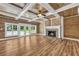 Cozy living room with wood paneling, beamed ceiling, fireplace, and French doors to the outside at 15 Porter Cir, Hampton, GA 30228