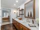 Stylish bathroom boasts dual sinks with marble countertops, floating shelves, and elegant wallpaper at 2270 Emerald Dr, Jonesboro, GA 30236