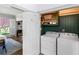 Convenient laundry room with white washer and dryer plus green storage cabinet and white door at 2270 Emerald Dr, Jonesboro, GA 30236