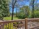 Picturesque backyard view from the deck featuring mature trees, lawn, and a glimpse of the lake at 2270 Emerald Dr, Jonesboro, GA 30236