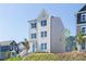 Three-story home featuring white and gray siding, paired with dark shutters and a neatly landscaped lawn at 620 Devon Aly, Acworth, GA 30102