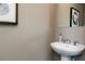 A half bathroom featuring a pedestal sink, neutral paint, framed art and a decorative mirror at 624 Devon Aly, Acworth, GA 30102