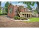 A beautiful backyard showcasing a brick home, lush greenery and a spacious deck at 8250 Saint Marlo Fairway Dr, Duluth, GA 30097
