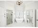 Bathroom with tub, glass enclosed shower, marble flooring, modern fixtures and stained glass window at 8250 Saint Marlo Fairway Dr, Duluth, GA 30097