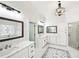 Bright bathroom with double vanity, quartz countertops, modern light fixture and glass shower at 8250 Saint Marlo Fairway Dr, Duluth, GA 30097