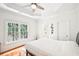 Inviting bedroom features tray ceilings, a large window providing ample light, and wood floors at 8250 Saint Marlo Fairway Dr, Duluth, GA 30097