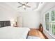 Bedroom featuring a window with backyard views, wood floors, a ceiling fan, and tray ceiling at 8250 Saint Marlo Fairway Dr, Duluth, GA 30097