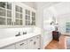 Elegant butler's pantry featuring white cabinets, subway tile backsplash, and quartz countertops at 8250 Saint Marlo Fairway Dr, Duluth, GA 30097