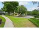 Community entrance with lush landscaping, sidewalks, and a view of the community clubhouse with pool and waterslide at 8250 Saint Marlo Fairway Dr, Duluth, GA 30097
