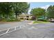 Community entrance with lush landscaping, sidewalks, and a view of the community clubhouse with pool and waterslide at 8250 Saint Marlo Fairway Dr, Duluth, GA 30097