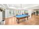 Spacious game room features a pool table, ample natural light, and luxury vinyl plank flooring at 8250 Saint Marlo Fairway Dr, Duluth, GA 30097