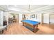 Spacious game room with beautiful hardwood floors, a pool table, and an adjacent formal dining area at 8250 Saint Marlo Fairway Dr, Duluth, GA 30097