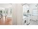 Bright laundry room with white washer and dryer and a view to the kitchen at 8250 Saint Marlo Fairway Dr, Duluth, GA 30097