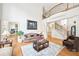 Spacious living room with hardwood floors, high ceilings, and staircase at 8250 Saint Marlo Fairway Dr, Duluth, GA 30097