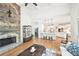 Cozy living room with stone fireplace, hardwood floors, and open kitchen at 8250 Saint Marlo Fairway Dr, Duluth, GA 30097
