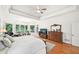 Bright primary bedroom suite with tray ceiling, hardwood floors and sitting area at 8250 Saint Marlo Fairway Dr, Duluth, GA 30097