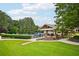 Well-manicured lawn area leading to a covered outdoor area and community pool at 8250 Saint Marlo Fairway Dr, Duluth, GA 30097