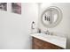 Stylish powder room with a carved wood vanity and a round mirror above at 8250 Saint Marlo Fairway Dr, Duluth, GA 30097