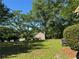 Private backyard with lush green lawn, mature trees and a garage in the background at 1280 Waterwood Dr, Loganville, GA 30052