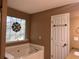 Bathroom with a large soaking tub and a stained glass window at 1280 Waterwood Dr, Loganville, GA 30052