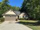 Exterior view of a single-story home with a two-car garage and beautiful stone accents at 1280 Waterwood Dr, Loganville, GA 30052