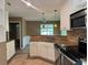 Modern kitchen boasts granite countertops, stainless steel appliances, and tile flooring for a stylish and functional space at 1280 Waterwood Dr, Loganville, GA 30052
