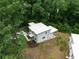 Aerial view of modern home with deck, unique rooftop green space, and surrounding lush greenery at 1604 Niskey Lake Rd, Atlanta, GA 30331
