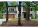 Modern two-story home with balcony, front lawn, and wood-look garage door at 1604 Niskey Lake Rd, Atlanta, GA 30331