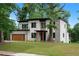Modern two-story home featuring a manicured lawn, a modern garage door, and a stone facade at 1604 Niskey Lake Rd, Atlanta, GA 30331