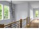 Upstairs hallway with modern railing, hardwood floors, and contemporary pendant lighting at 1604 Niskey Lake Rd, Atlanta, GA 30331