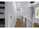 Hallway features hardwood floors, a modern light fixture, and wood and steel railing at 1604 Niskey Lake Rd, Atlanta, GA 30331