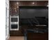 Modern kitchen showcasing a center island with black marble countertops and stainless steel double ovens at 1604 Niskey Lake Rd, Atlanta, GA 30331