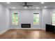 Bright living room featuring hardwood floors, modern fireplace, ceiling fan, and large windows with natural light at 1604 Niskey Lake Rd, Atlanta, GA 30331