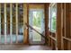 View of the unfinished room with a wooden frame, insulation, a white door, and several windows at 1604 Niskey Lake Rd, Atlanta, GA 30331