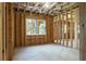 Unfinished room boasts wood framing, exposed ceiling, insulation, and two windows at 1604 Niskey Lake Rd, Atlanta, GA 30331