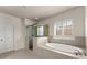 Beautiful bathroom with walk-in glass shower and soaking tub beneath a window with shutters at 3317 Sweetleaf Ln, Buford, GA 30519