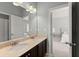 Modern bathroom featuring double sinks with stone countertops and a doorway leading to a bedroom at 3317 Sweetleaf Ln, Buford, GA 30519