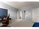 A bedroom with neutral walls and carpet, along with a desk setup and multiple doorways at 3317 Sweetleaf Ln, Buford, GA 30519