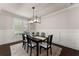 Dining room with a black table, white chairs, and a modern chandelier at 3317 Sweetleaf Ln, Buford, GA 30519