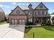 Beautiful brick home featuring a manicured lawn, two-car garage, and covered front porch at 3317 Sweetleaf Ln, Buford, GA 30519