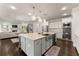 Open-concept kitchen featuring a large island with seating, stainless steel appliances, and modern lighting at 3317 Sweetleaf Ln, Buford, GA 30519
