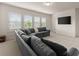 Spacious living room features a comfortable gray sectional sofa, large windows, and bright lighting at 3317 Sweetleaf Ln, Buford, GA 30519